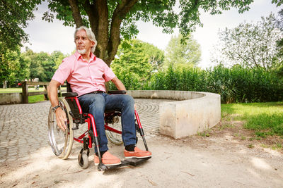 Portrait of man sitting on bicycle against trees