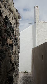 Stone wall by sea against sky