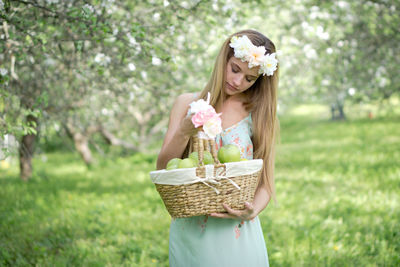 Woman wearing hat standing in basket on field