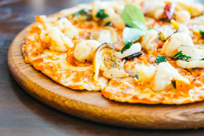 Close-up of pizza on cutting board at table