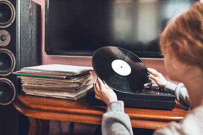 Woman playing music from vinyl record. analog record. retro and vintage style. hobby and passion