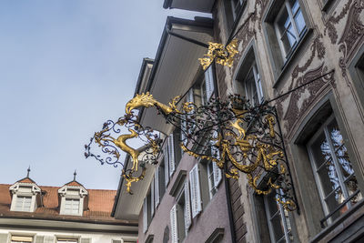 Low angle view of statues on building against sky