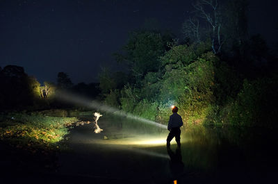 Full length of man standing on illuminated street at night