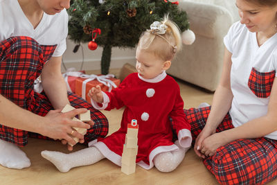 Midsection of woman holding christmas tree at home