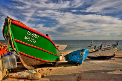 Boats moored on beach against sky