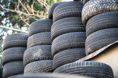 Old used rubber tires stacked with high piles. hazardous waste requiring recycling and disposal.