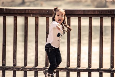 Portrait of girl standing against railing