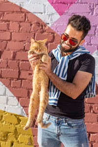 Full length of a man with dog against wall