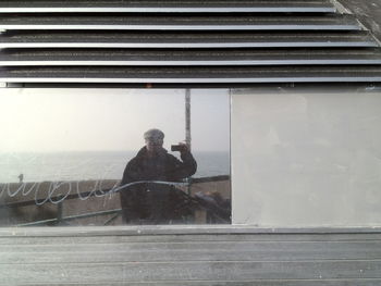 View of man sitting against window