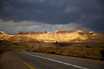 Road leading towards mountains against sky