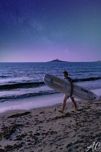 Man on beach against sky at night
