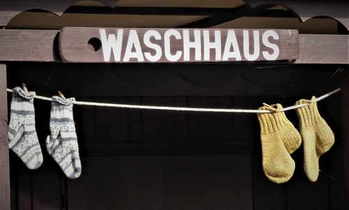 Close-up of clothespins hanging on rope against wall