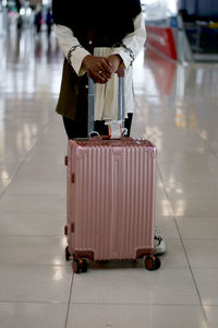 Low section of woman standing on floor at airport