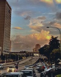 Traffic on road against cloudy sky