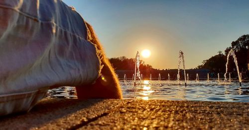 Surface level of swimming pool at beach against sky during sunset