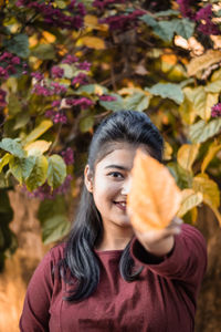 Portrait of woman holding leaf