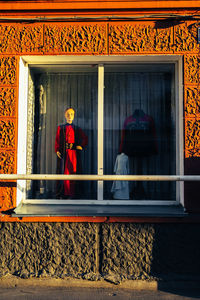 Man standing against window of building