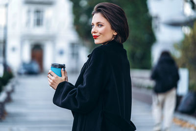 Side view of young woman standing outdoors