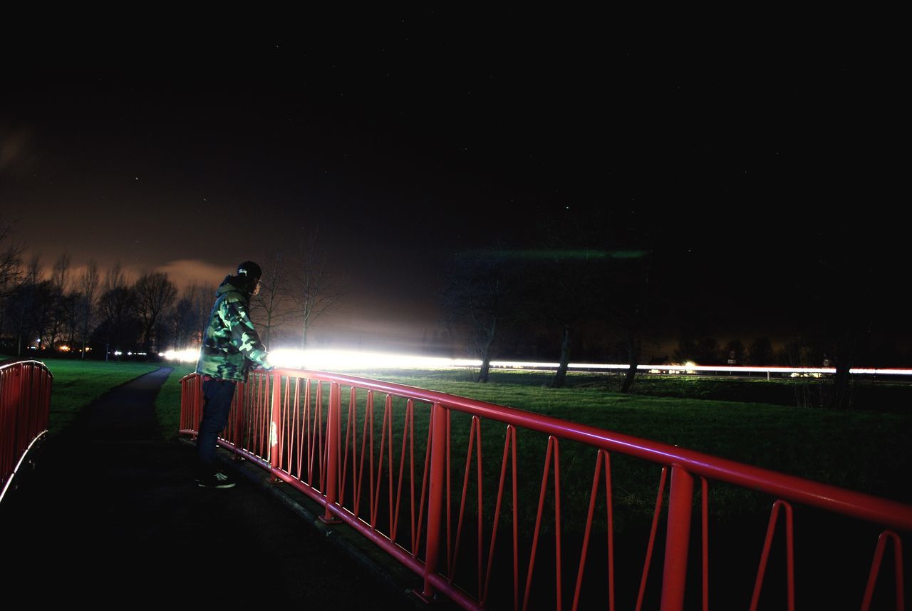 night, illuminated, light trail, road, transportation, long exposure, the way forward, street light, motion, speed, sky, diminishing perspective, street, tree, road marking, lighting equipment, vanishing point, railing, outdoors, grass