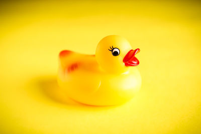 Close-up of yellow toy over colored background