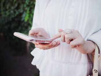 Midsection of woman holding mobile phone