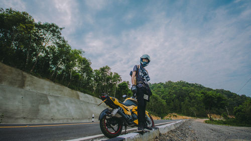 Man riding bicycle on road against sky