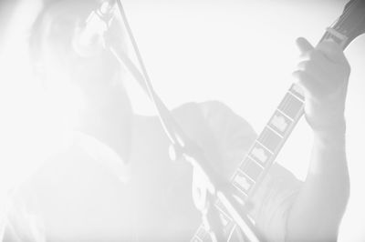 Low angle view of musician singing and playing guitar