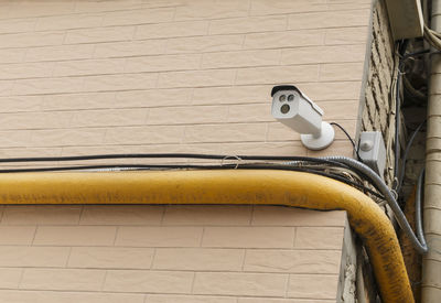 Low angle view of security camera on wall