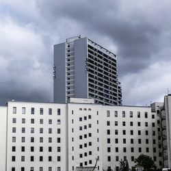 Low angle view of buildings against cloudy sky