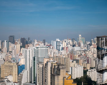 Aerial view of buildings in city against sky