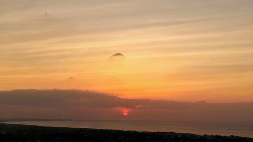 Scenic view of sea against romantic sky at sunset