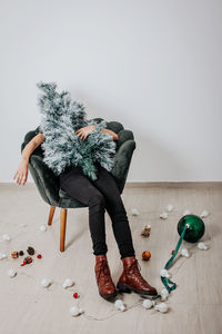 Full length of woman sitting on floor against white background