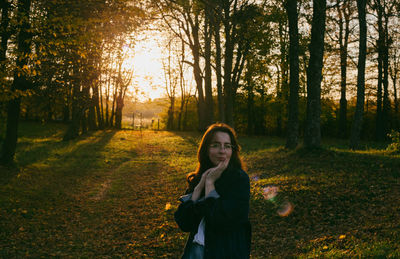 Portrait of young woman standing in forest