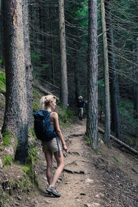 Rear view of woman standing in forest