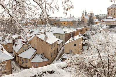 Prague castle with the rooftops of buildings of new world area in winter with snow.