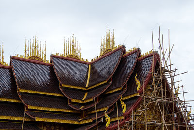 The traditional thai style church with the bamboo scaffolding to paint the gable.
