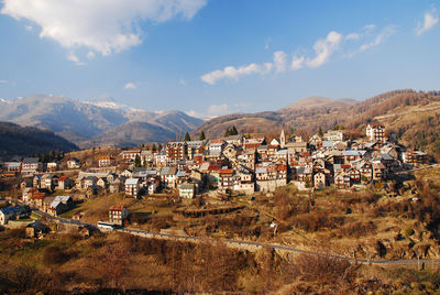 Panoramic view of townscape and mountains against sky