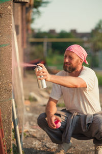 Full length of a man drinking coffee while sitting outdoors