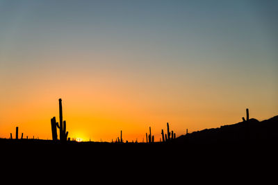 Silhouette of construction site against clear sky during sunset
