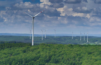 Windmills on field against sky