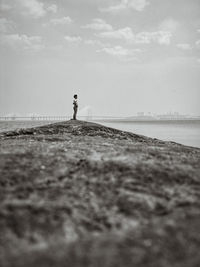Man standing by sea against sky