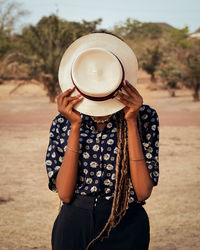 Woman covering face with hat