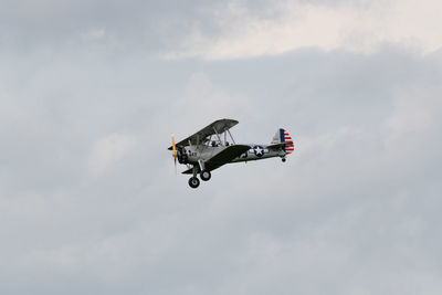 Low angle view of airplane flying against sky