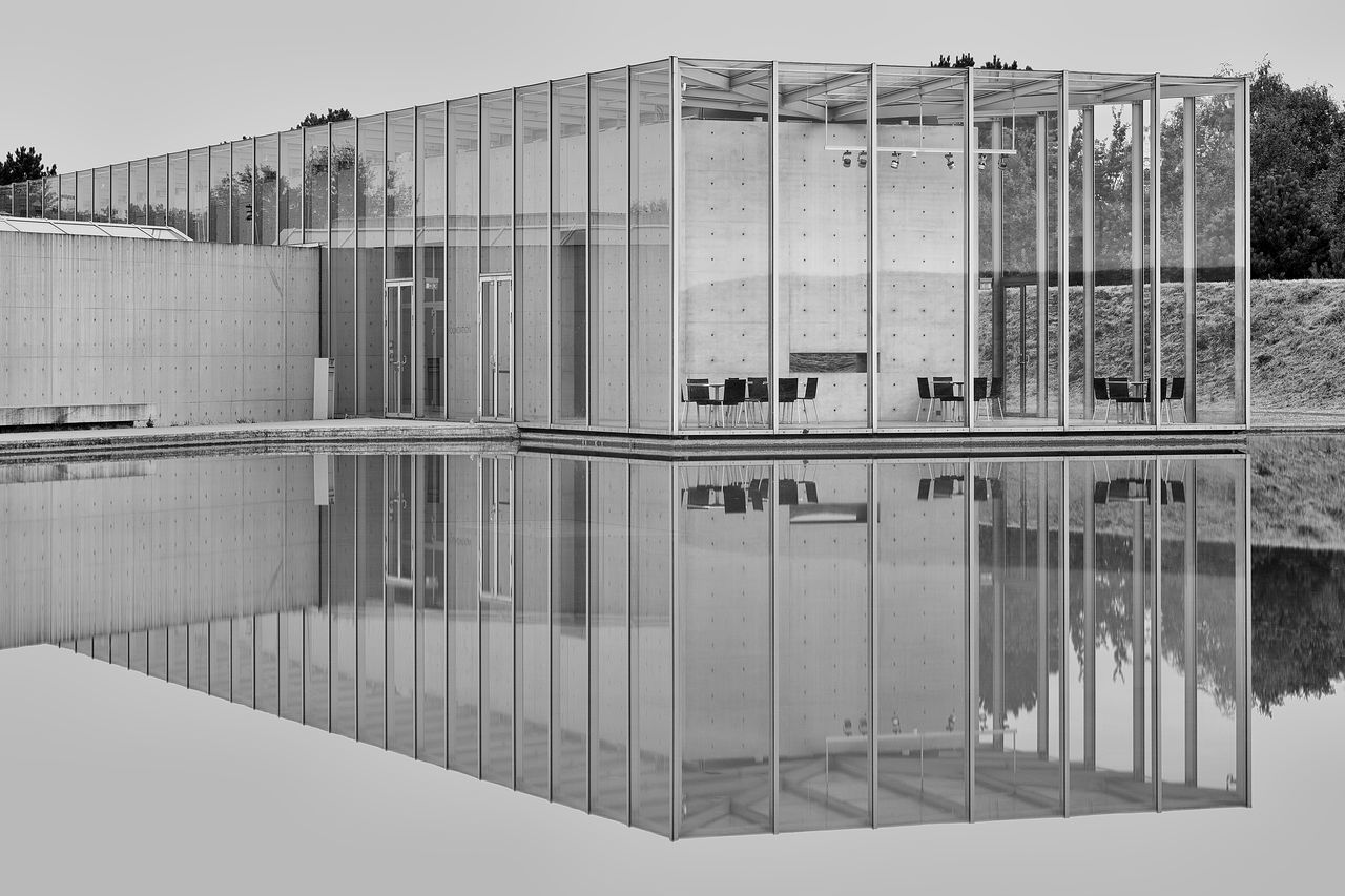 reflection, architecture, built structure, building exterior, no people, water, day, waterfront, building, glass - material, nature, sky, lake, outdoors, standing water, symmetry, city, clear sky, transparent, reflecting pool