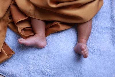 High angle view of baby feet on bed