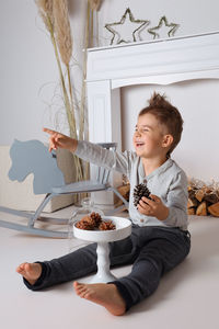Happy little boy playing with pine cones. laughing child, christmas decoration. celebration 
