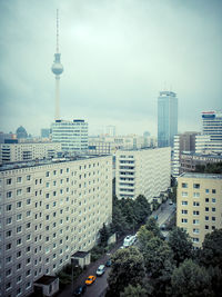 Fernsehturm by buildings in city against sky