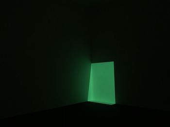 Illuminated lamp against black background