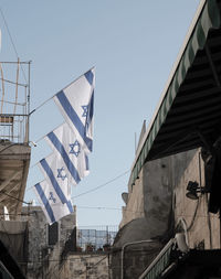 Low angle view of flags hanging against buildings in city