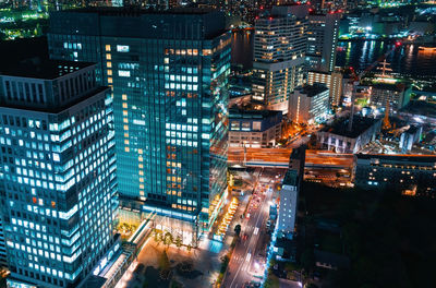 High angle view of illuminated street amidst buildings at night